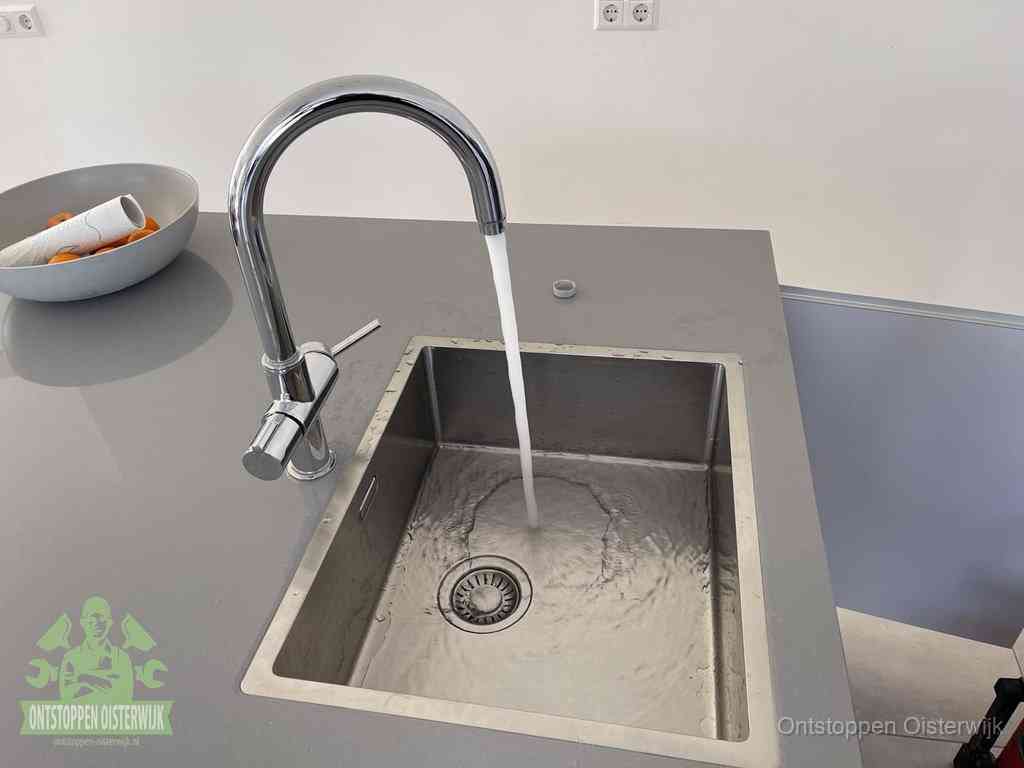 Een vrij doorstromende rvs spoelbak waar het water moeiteloos wegloopt, het resultaat van slim onderhoud dat geld bespaart in Oisterwijk