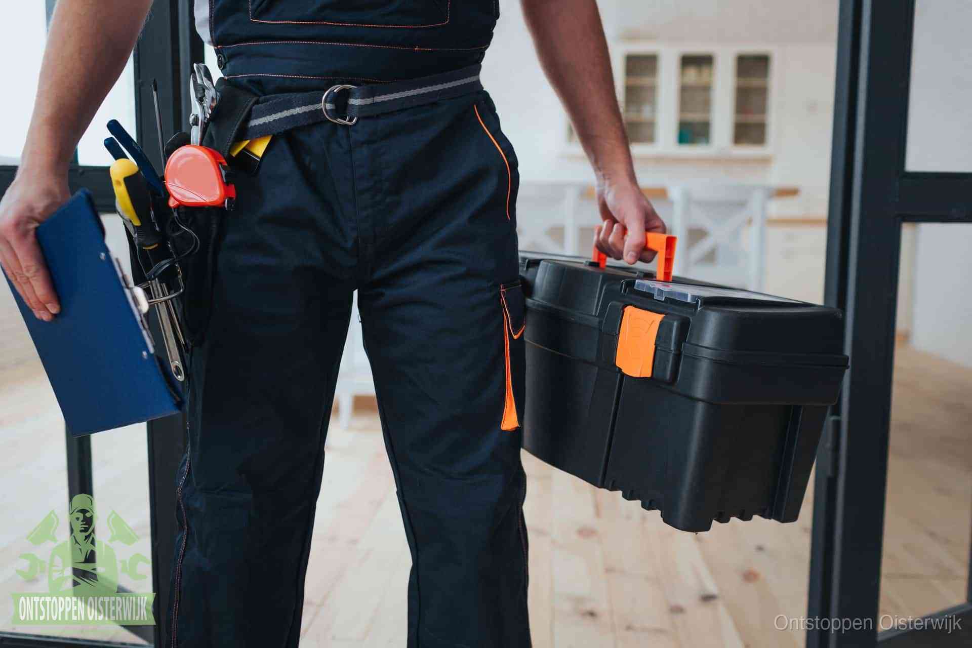Een monteur met gereedschapsriem en klembord in een keuken, klaar om een transparante prijs voor het gootsteen ontstoppen in Oisterwijk te geven