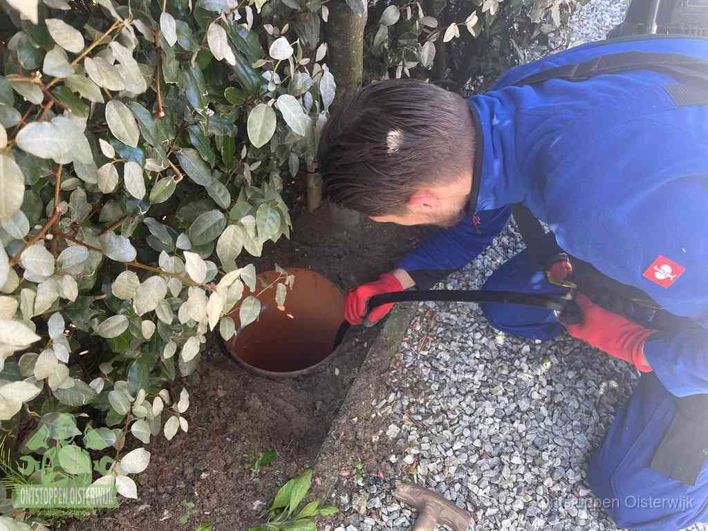 Monteur reinigt een rioolput met een slang, periodieke rioolreiniging in Oisterwijk