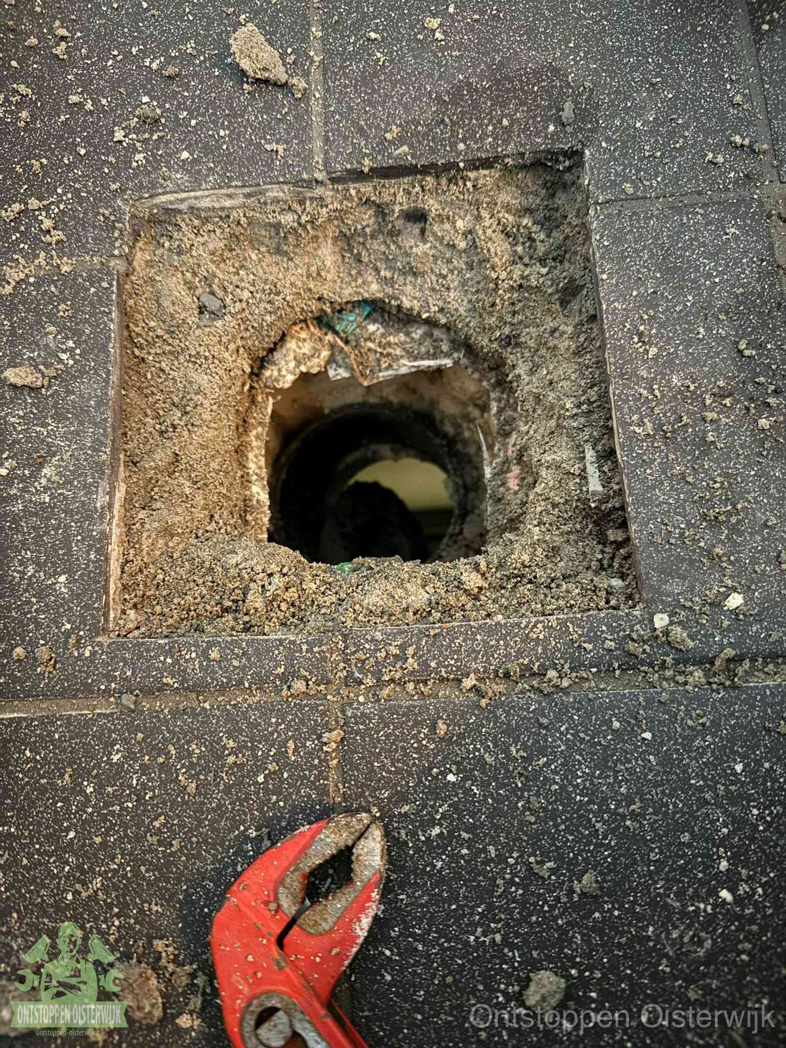 Geopend rioolputje op de erfgrens dat laat zien wie eigenaar is van de riolering in Oisterwijk