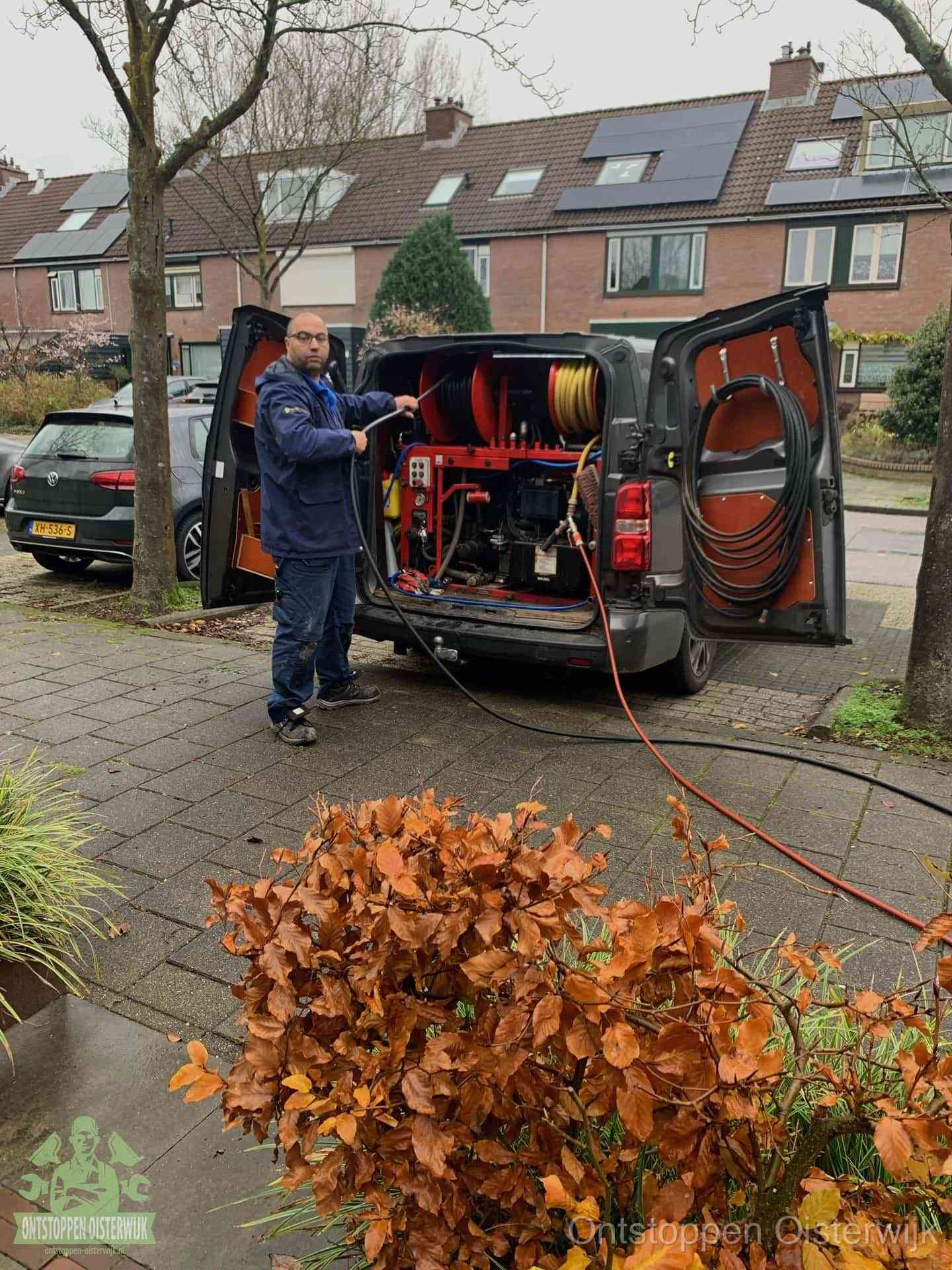 Monteur met rioolreinigingsbus levert rioolservice in de wijk in Oisterwijk