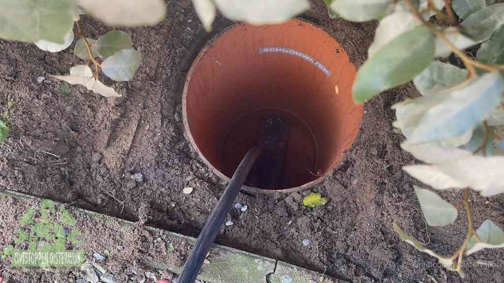 Open inspectieput in de tuin waar een veer rioolvliegjes en stankoverlast aanpakt in Oisterwijk