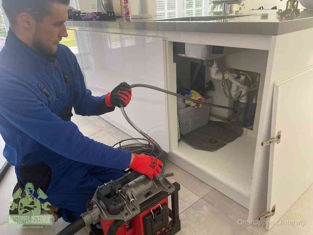 Een monteur reinigt de keukenafvoer grondig met een veermachine om terugkerende gootsteenverstoppingen te voorkomen in Oisterwijk