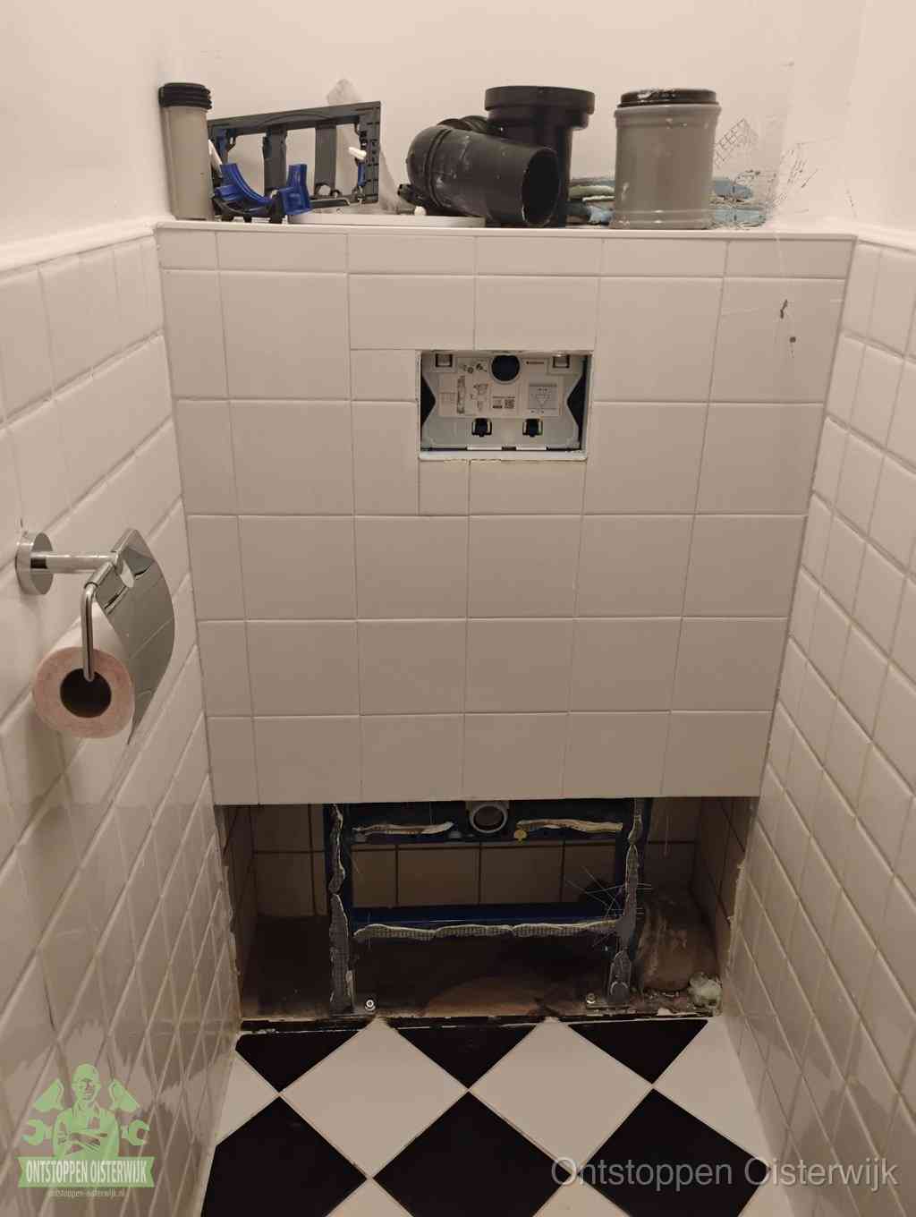 Een toiletruimte waar het hangtoilet en de inbouwreservoir-onderdelen zijn vrijgelegd voor onderhoud, periodiek nazicht voorkomt een wc-verstopping in Oisterwijk