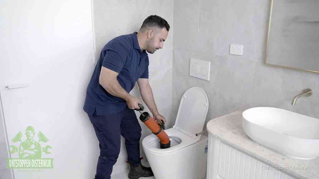 Een monteur gebruikt een handmatige perspomp (toiletontstopper) op een wandcloset tijdens het professioneel wc ontstoppen in Oisterwijk
